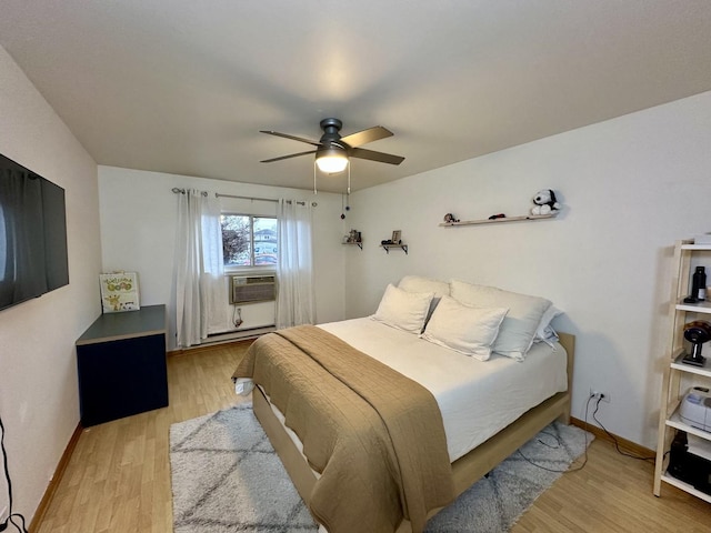 bedroom with ceiling fan, cooling unit, and light hardwood / wood-style flooring