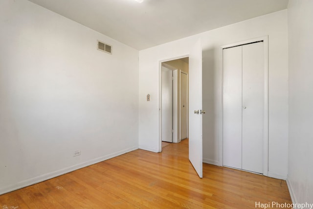 unfurnished bedroom with light hardwood / wood-style floors and a closet