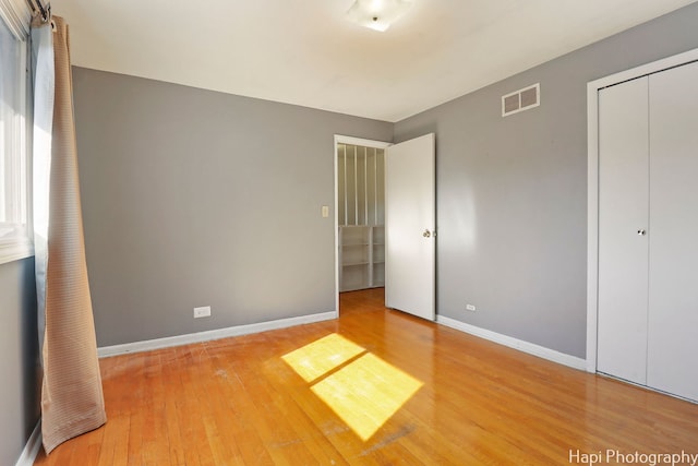 unfurnished bedroom featuring a closet and hardwood / wood-style floors