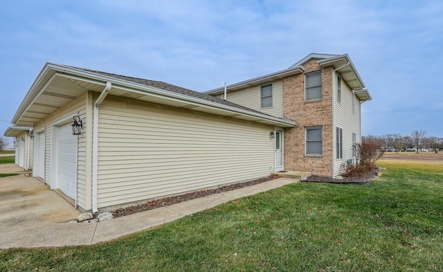 view of side of home with a garage and a lawn