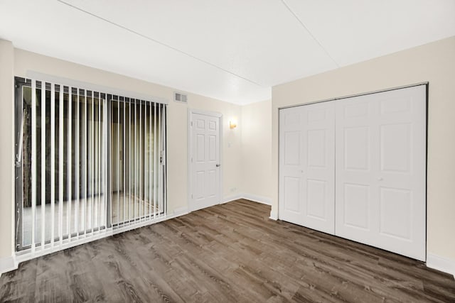 unfurnished bedroom featuring dark hardwood / wood-style floors and a closet