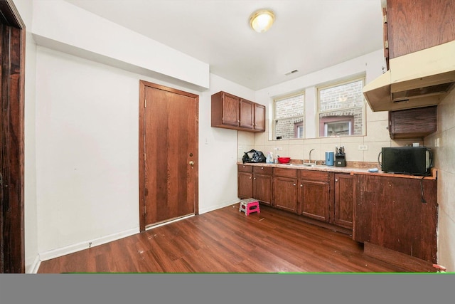 kitchen featuring decorative backsplash, dark wood-type flooring, and sink