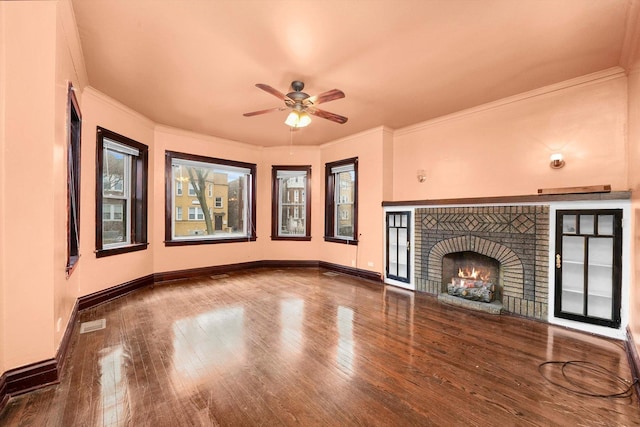 unfurnished living room featuring ceiling fan, a fireplace, wood-type flooring, and ornamental molding