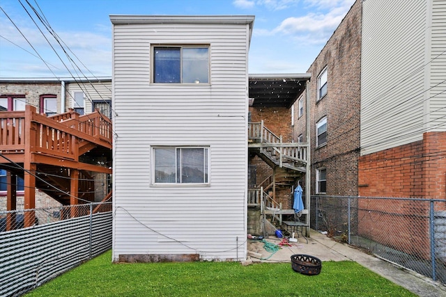 rear view of house featuring a lawn and a fire pit