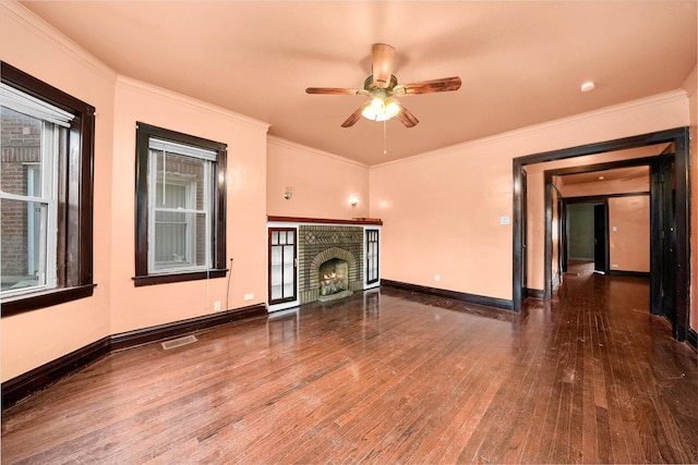 unfurnished living room featuring a fireplace, hardwood / wood-style floors, ceiling fan, and crown molding