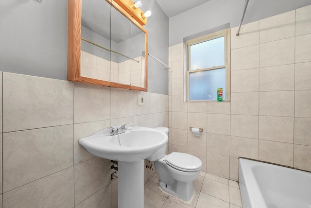 bathroom featuring a bathing tub, tile patterned flooring, toilet, and tile walls