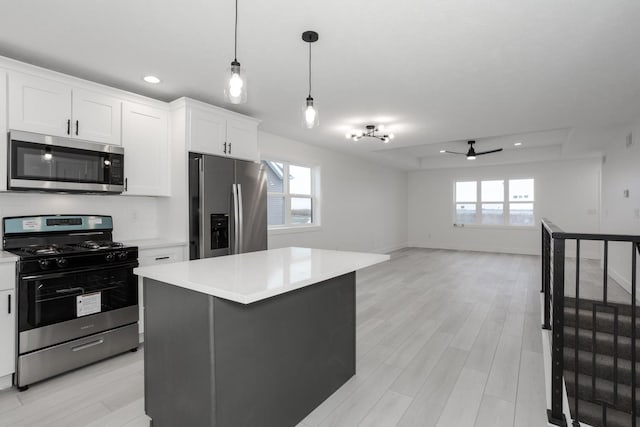 kitchen featuring a center island, a healthy amount of sunlight, white cabinetry, and stainless steel appliances