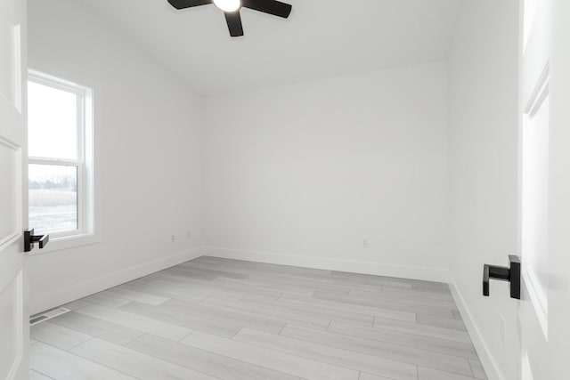 empty room featuring ceiling fan, light hardwood / wood-style floors, and lofted ceiling