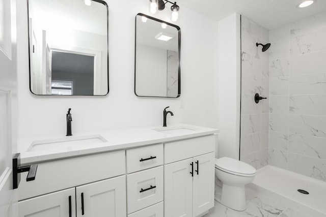 bathroom featuring vanity, toilet, and a tile shower