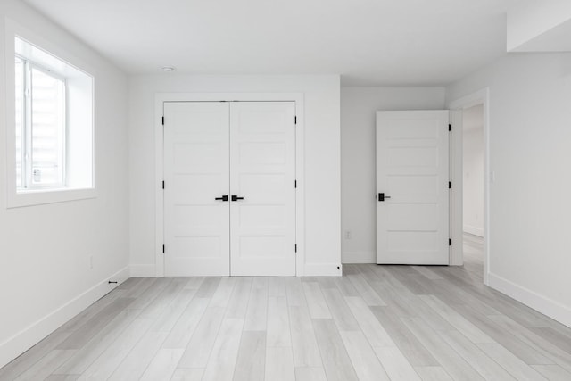 unfurnished bedroom with a closet and light hardwood / wood-style flooring