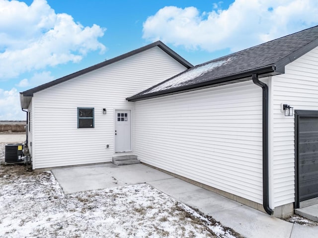 snow covered back of property with central air condition unit