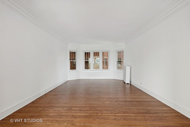 empty room with radiator, crown molding, and dark hardwood / wood-style floors