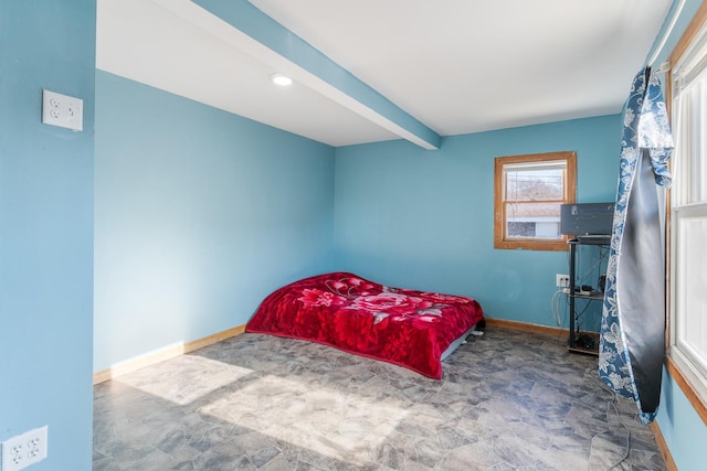 bedroom with beamed ceiling and baseboards