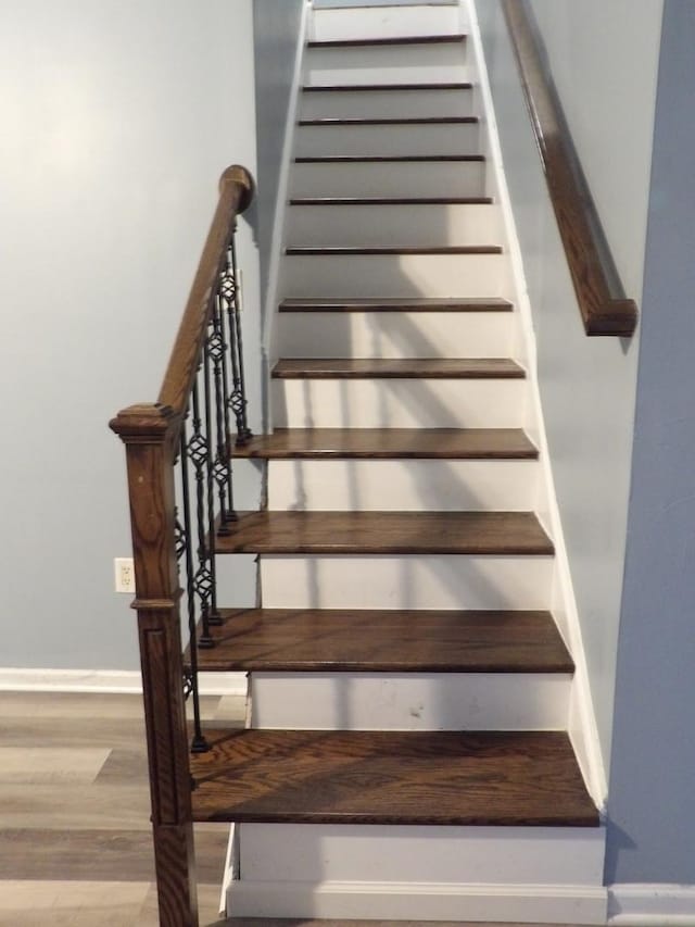 stairs with baseboards and wood finished floors