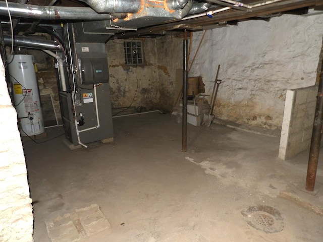 unfinished basement featuring gas water heater and heating unit