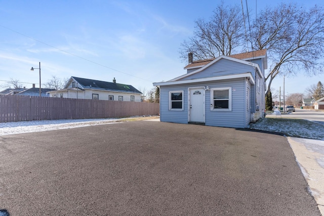 view of front of house with a chimney and fence