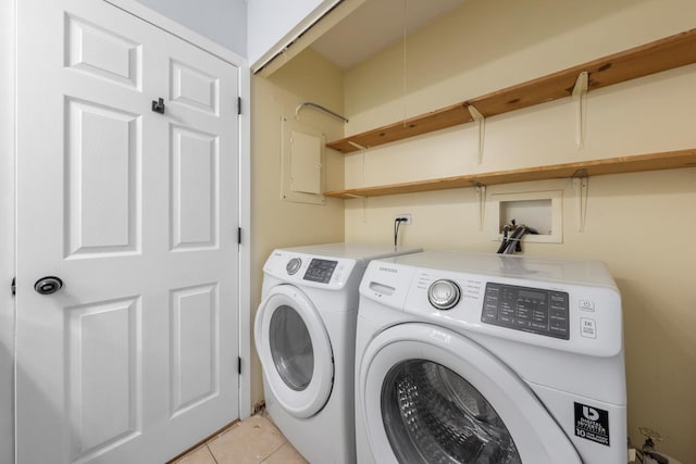 clothes washing area featuring washer and clothes dryer and light tile patterned floors