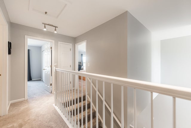 hall with light carpet and track lighting