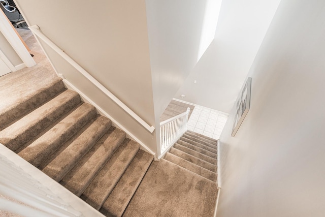 stairway featuring carpet