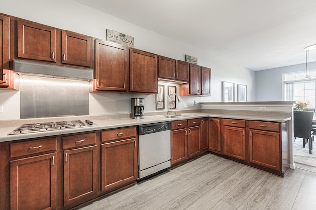 kitchen featuring sink, stainless steel appliances, light hardwood / wood-style floors, and kitchen peninsula