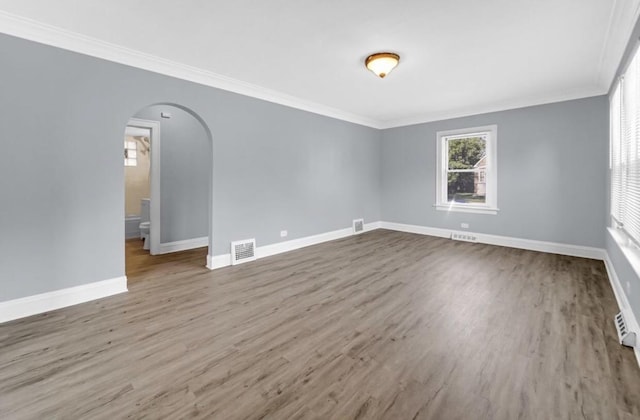 empty room with hardwood / wood-style floors and ornamental molding