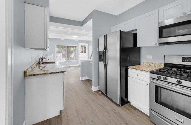 kitchen featuring white cabinets, light hardwood / wood-style floors, sink, and stainless steel appliances