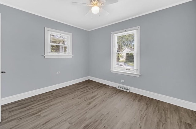 spare room featuring hardwood / wood-style flooring, ceiling fan, a healthy amount of sunlight, and ornamental molding