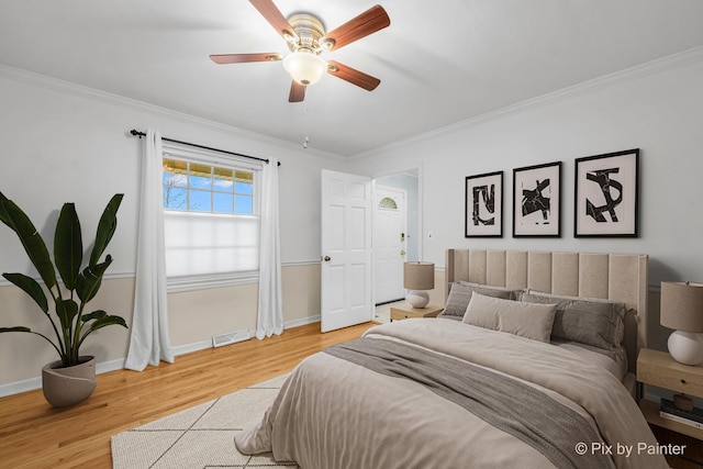 bedroom featuring ceiling fan, ornamental molding, and hardwood / wood-style flooring