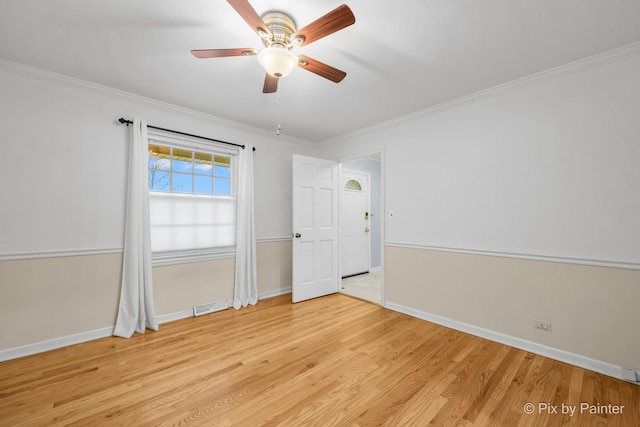 empty room featuring crown molding, light hardwood / wood-style flooring, and ceiling fan