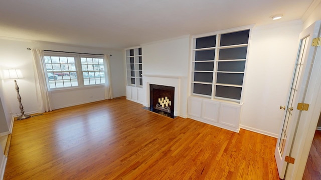 unfurnished living room with hardwood / wood-style flooring and ornamental molding