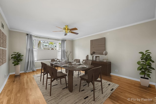 dining area featuring light wood-type flooring, ceiling fan, and ornamental molding