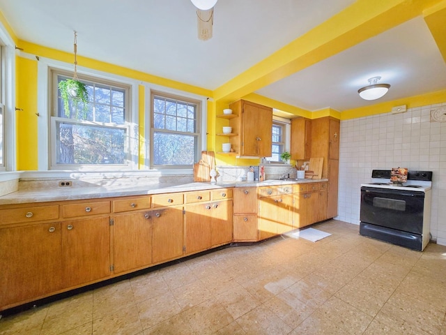 kitchen featuring black electric range, pendant lighting, decorative backsplash, and ceiling fan