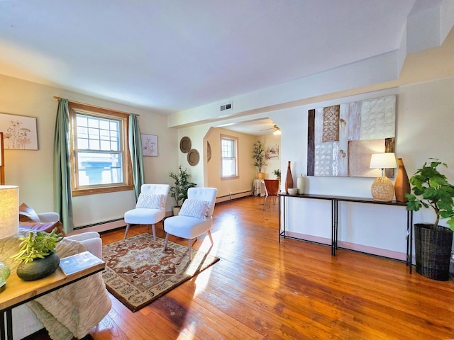 living room featuring hardwood / wood-style flooring, plenty of natural light, and a baseboard radiator