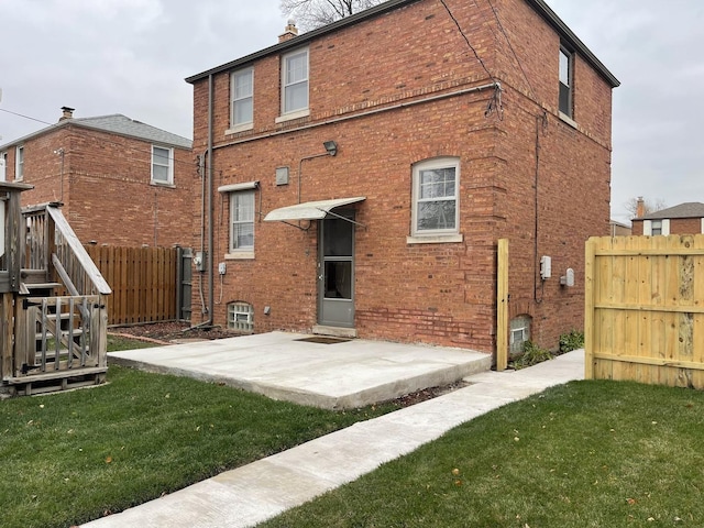 back of house with a yard and a patio