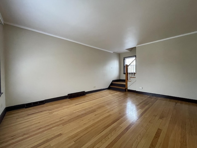 spare room with crown molding and light hardwood / wood-style floors