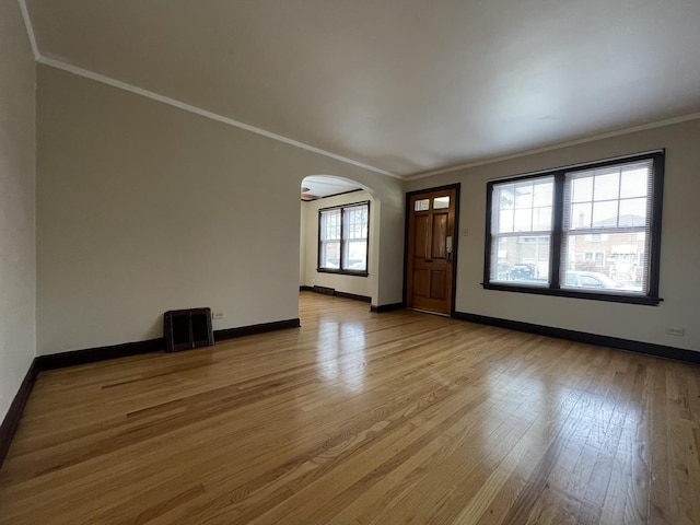 interior space featuring plenty of natural light, ornamental molding, and light wood-type flooring