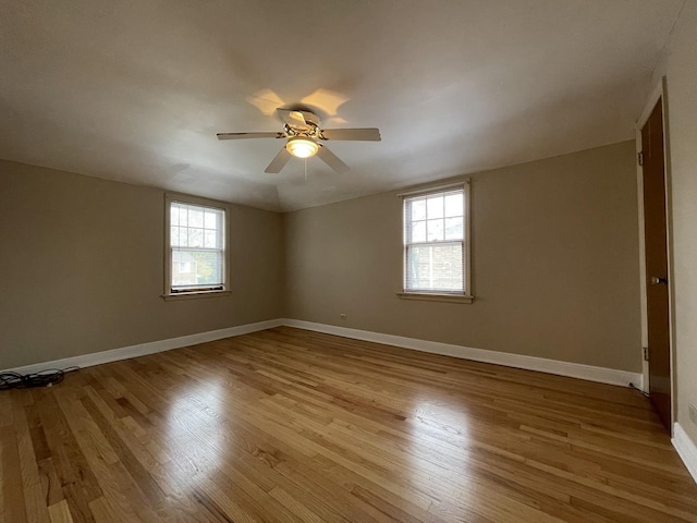 empty room with ceiling fan, a healthy amount of sunlight, and light hardwood / wood-style floors