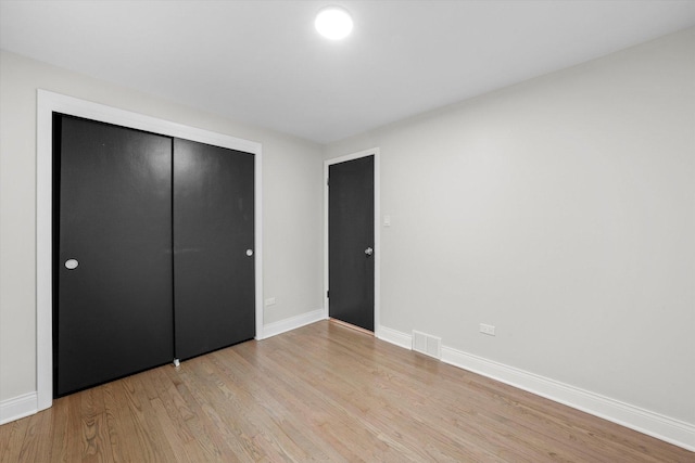 unfurnished bedroom with a closet and light wood-type flooring