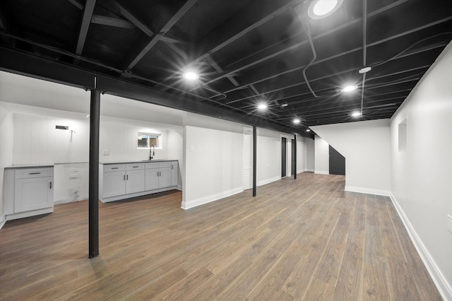 basement with sink and wood-type flooring