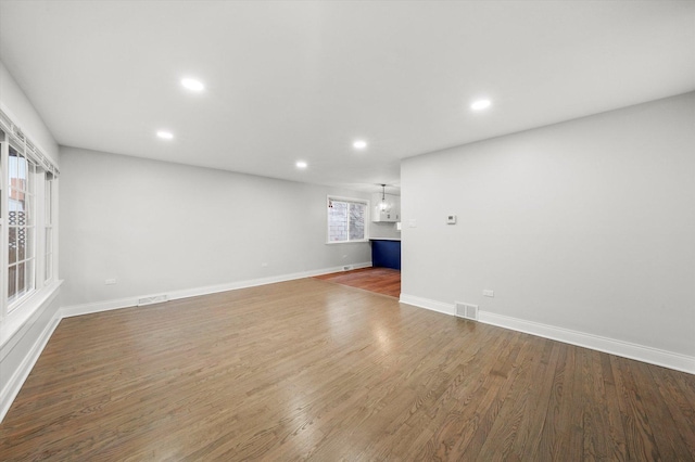 unfurnished living room featuring hardwood / wood-style flooring and a wealth of natural light