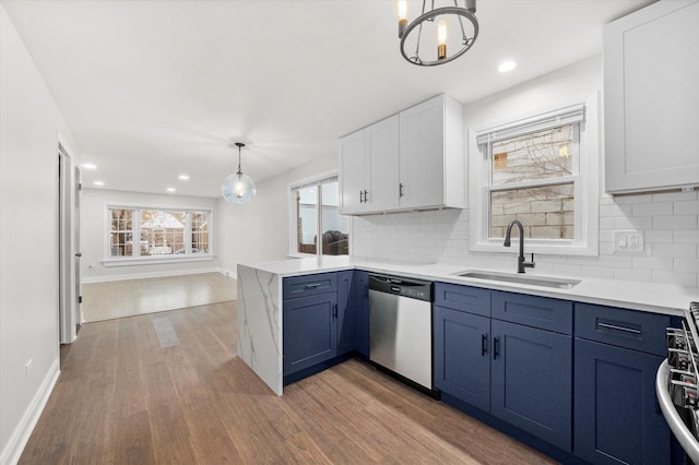 kitchen with white cabinetry, sink, pendant lighting, appliances with stainless steel finishes, and hardwood / wood-style flooring