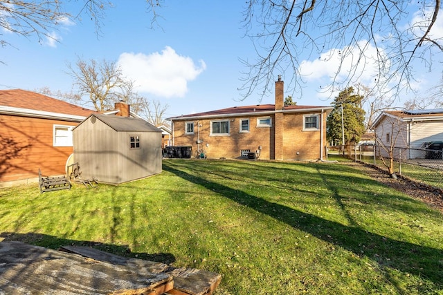 back of house featuring a yard and a storage unit