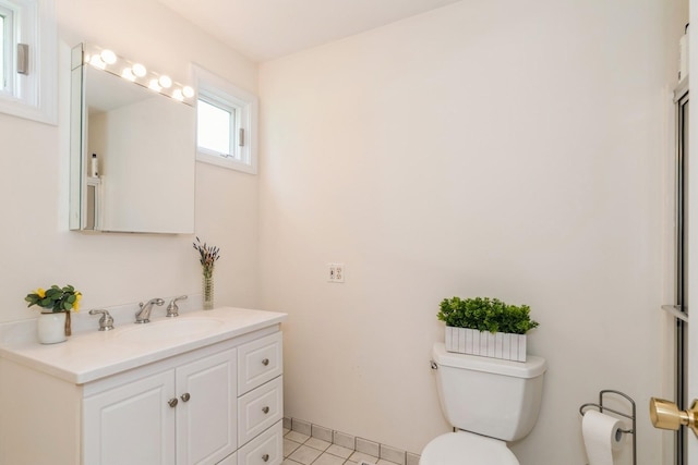 bathroom with tile patterned flooring, vanity, and toilet