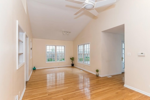 empty room with ceiling fan, light hardwood / wood-style flooring, and vaulted ceiling