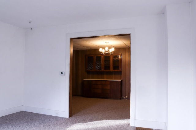 401 Ash Ave, Morrison, IL 61270 - spare room with carpet, a chandelier, and wooden walls