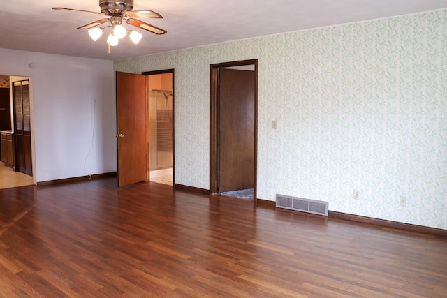 401 Ash Ave, Morrison, IL 61270 - unfurnished bedroom with wallpapered walls, wood finished floors, and ceiling fan