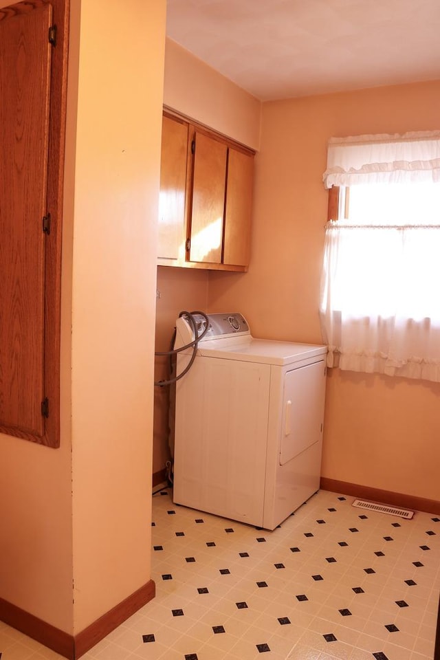 washroom with cabinets and washer / dryer