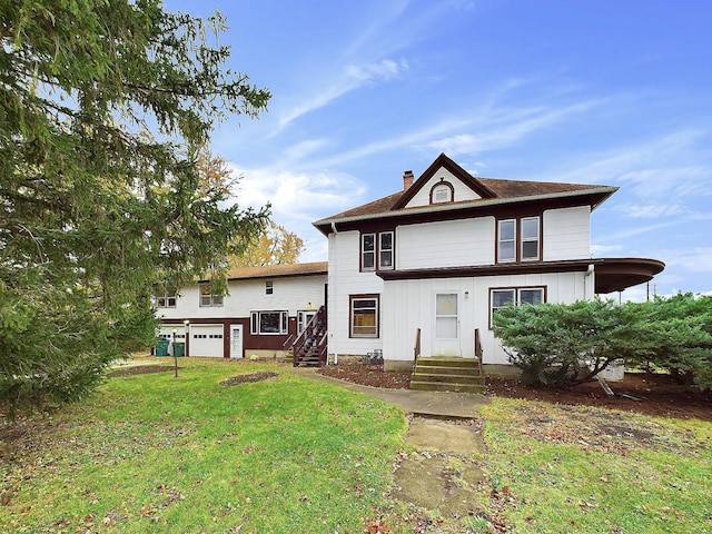 back of house featuring a garage, a chimney, board and batten siding, and a lawn