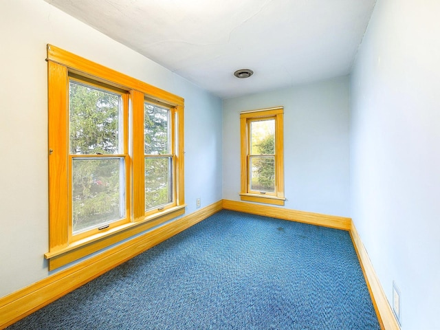 carpeted empty room with baseboards