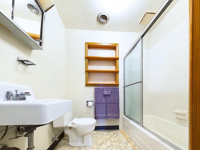 bathroom featuring visible vents, toilet, and bath / shower combo with glass door